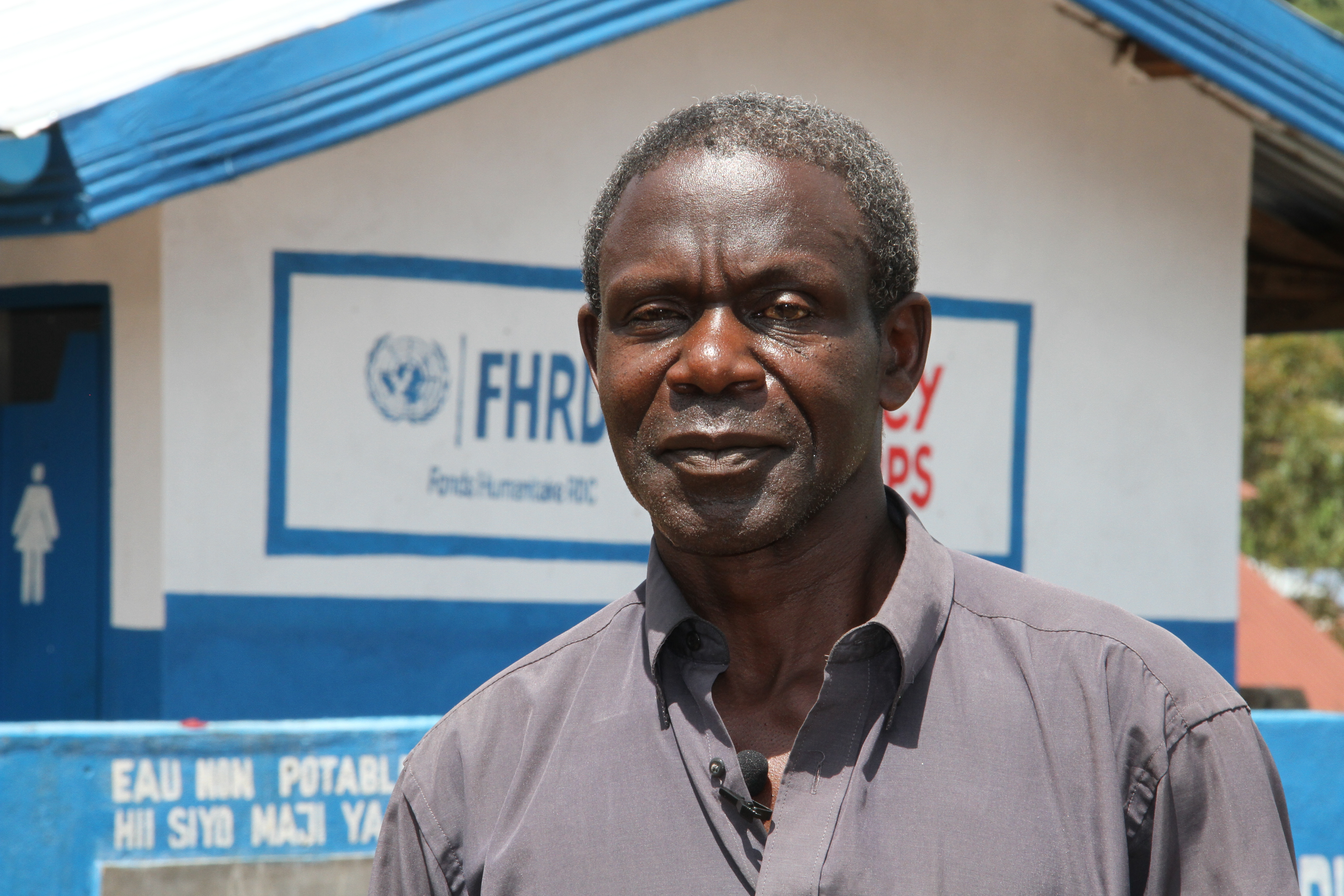 Mercy Corps employee stands in front of office.
