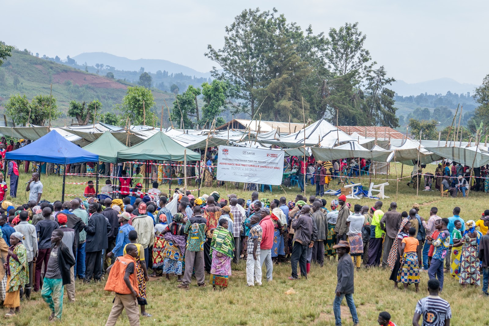 A large group of people at an outdoor distribution event.