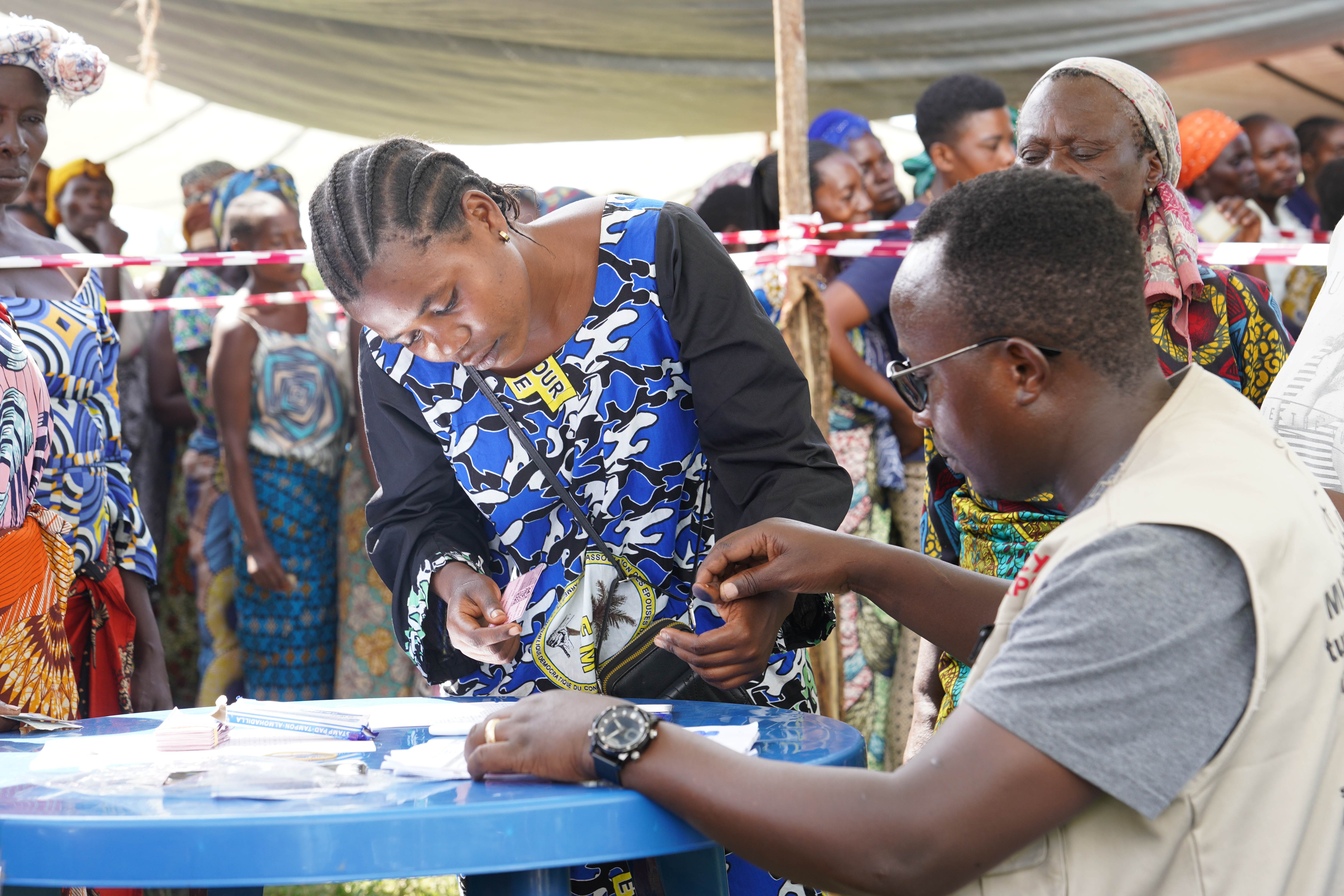 Two individuals in DRC work together at a table.