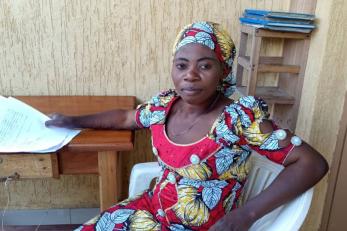 Congolese woman sitting at a desk.