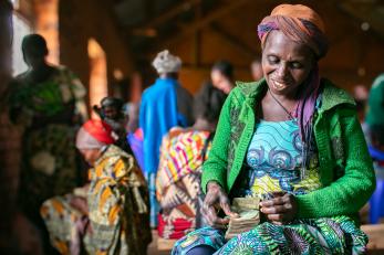 Woman sitting inside with community members.