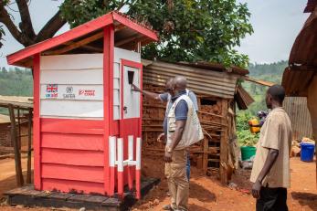 Mercy corps employees inspect toilets under construction.