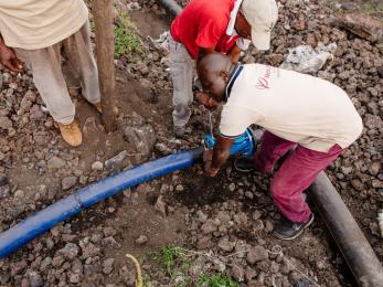 Men work to connect water pipes in dr congo
